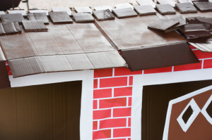 Cardboard box playhouse - laying down shingles