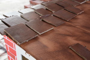 Cardboard box playhouse - gluing down shingles